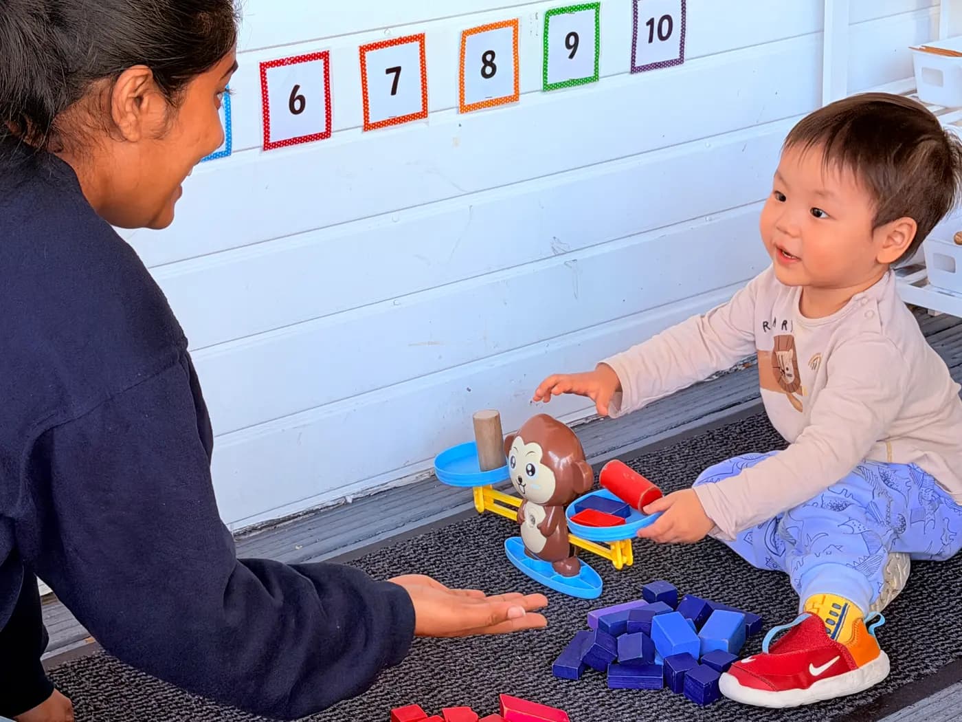 A child building words on a letter board with an educator at Blue Nest Montessori Harrow