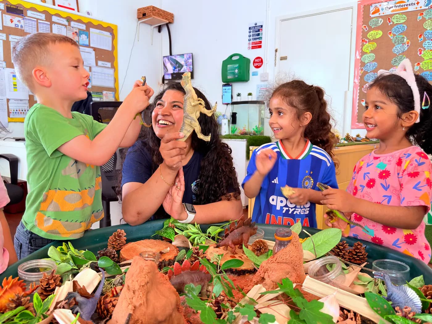 Children exploring a small-world village display in the Blue Nest Pinner garden