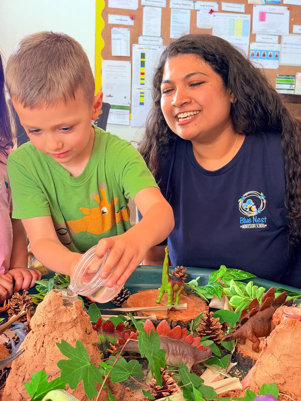 An educator and children at a busy activity table at Blue Nest Pinner