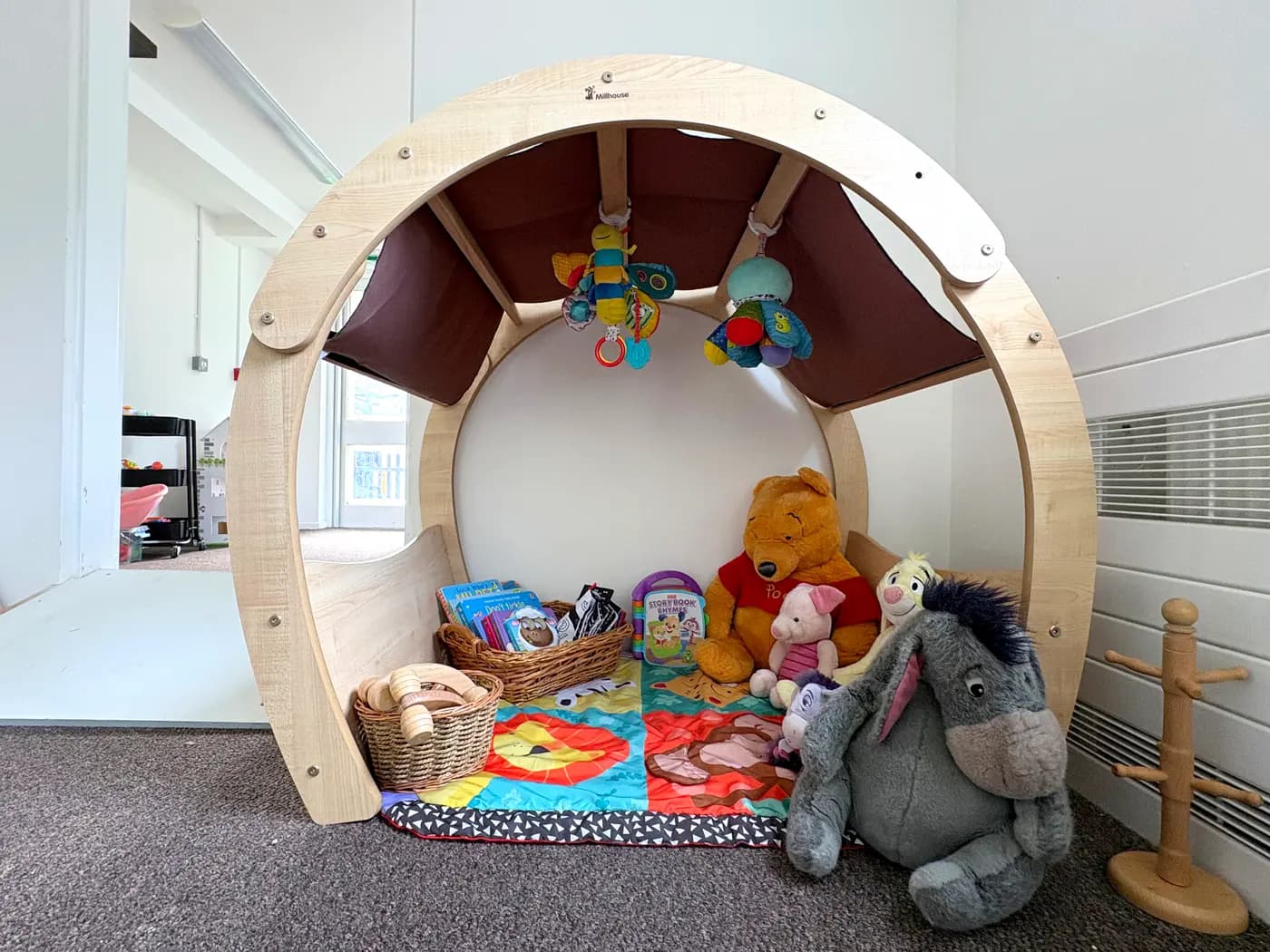 A cosy reading den with soft toys and board books at Blue Nest Montessori Aldershot