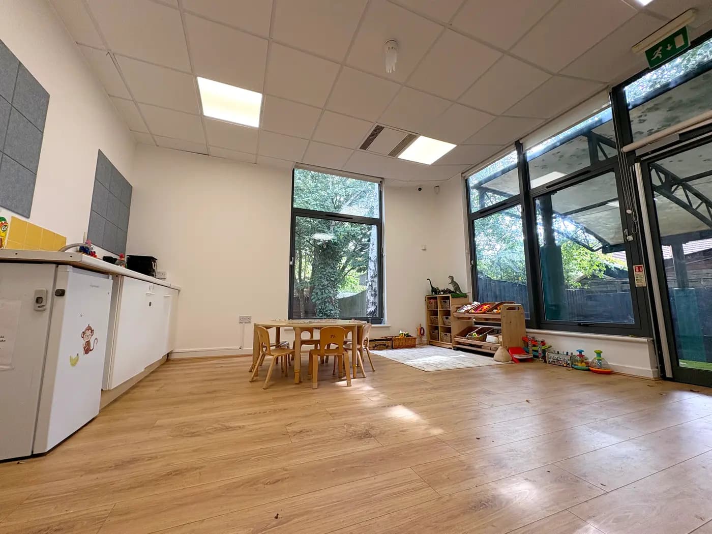 The bright preschool room with floor-to-ceiling garden windows at Blue Nest Montessori Aldershot