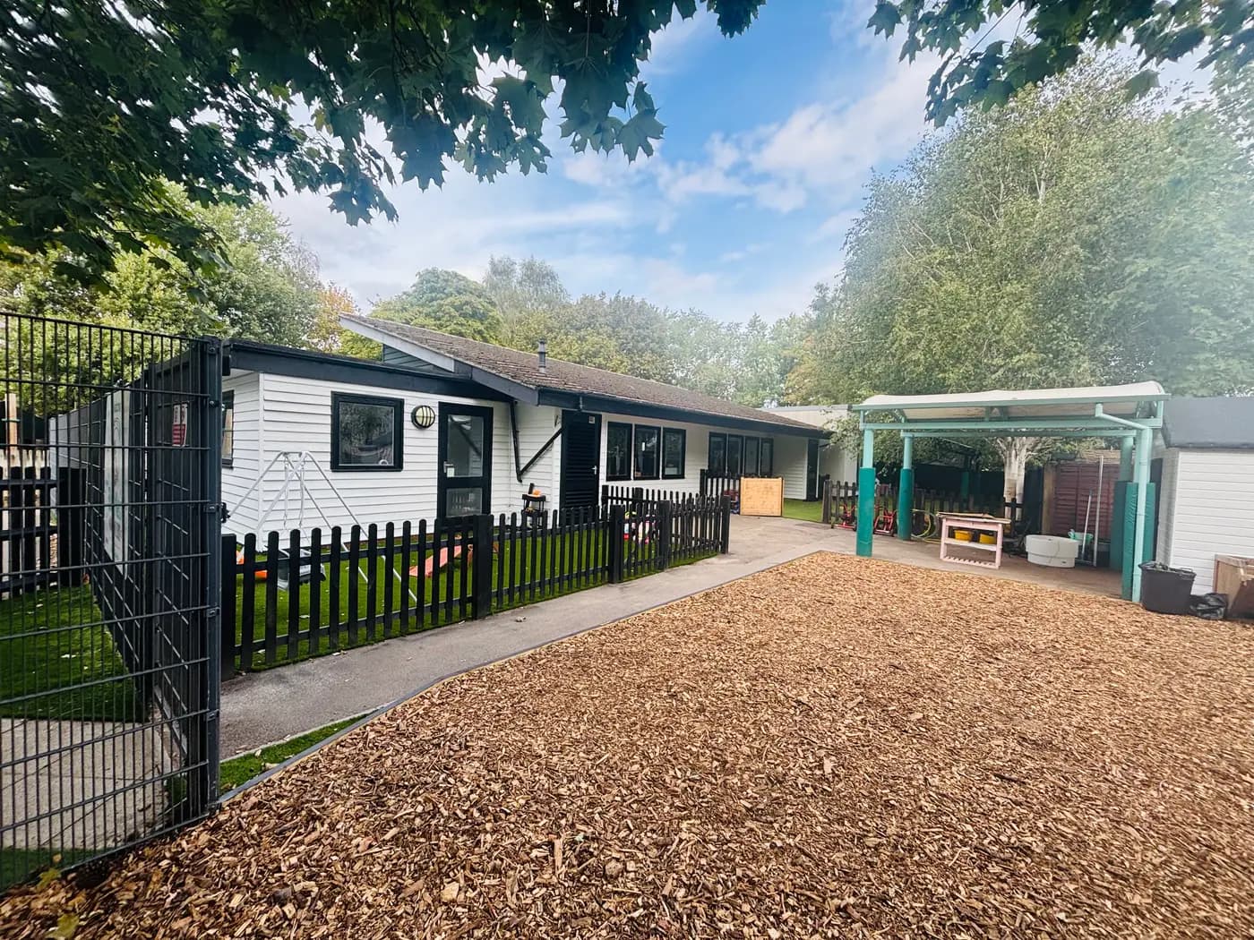 The nursery building and bark-chip play yard at Blue Nest Montessori Aldershot